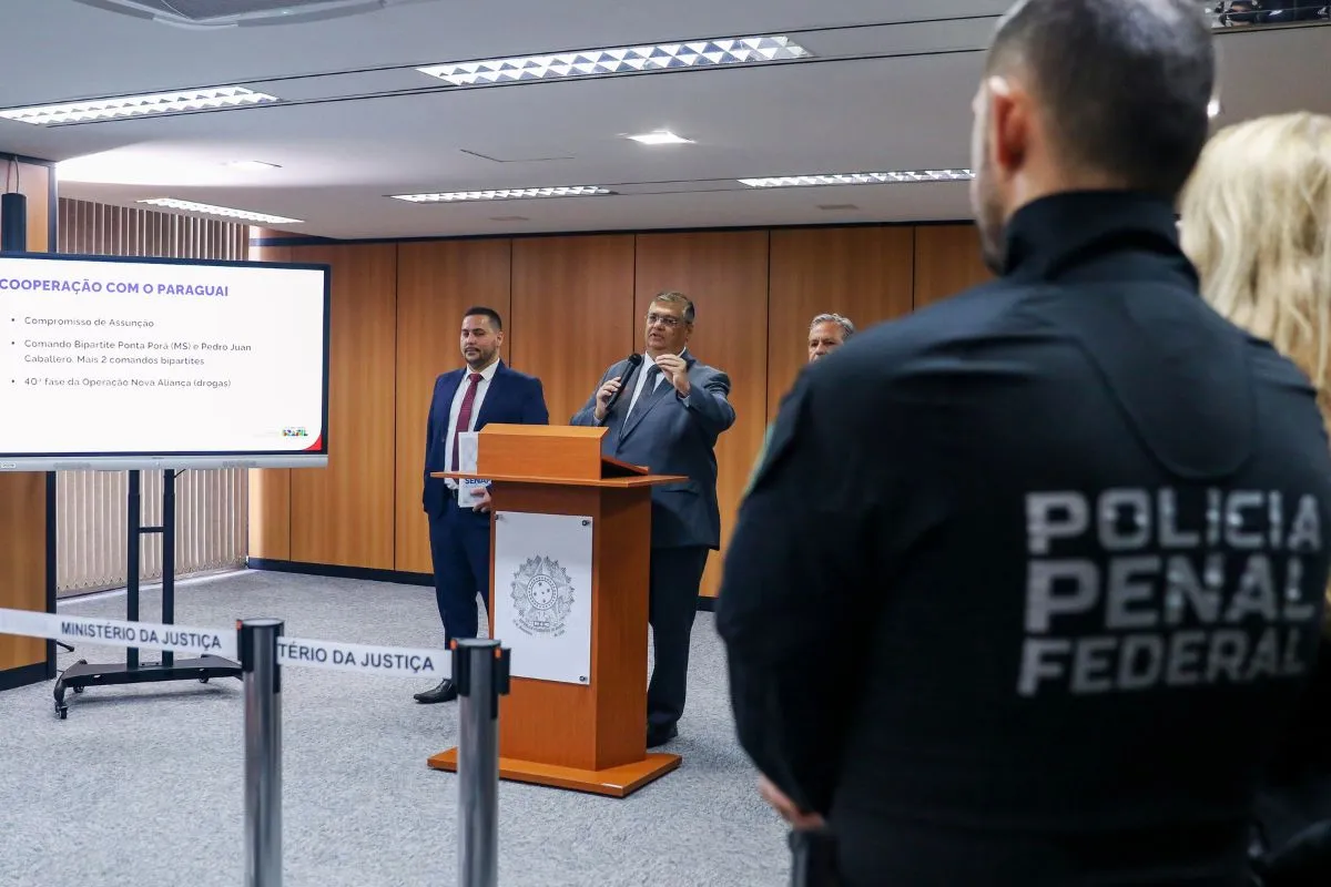 Autoridades do Ministério da Justiça apresentam acordo de cooperação com o Paraguai durante coletiva de imprensa, com agente da Polícia Penal Federal em destaque.