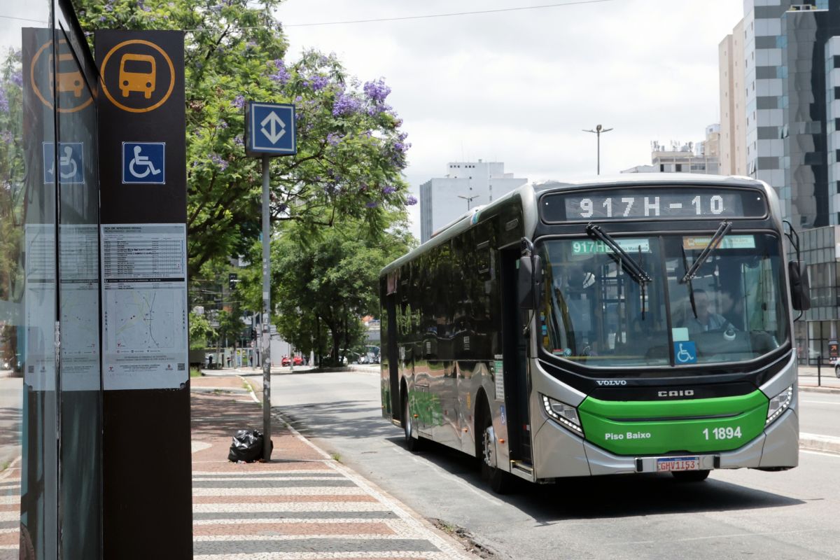Ônibus urbano acessível em ponto de parada com sinalização de transporte público e acessibilidade no Brasil.