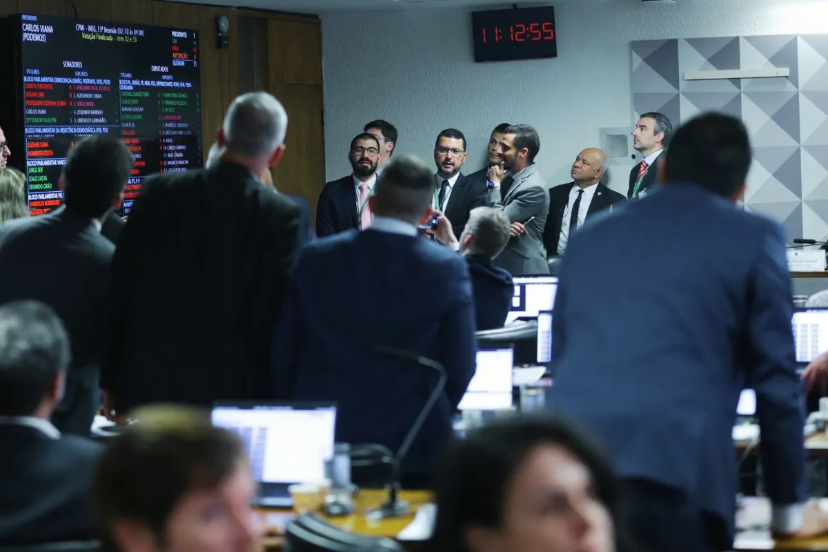 Senadores e parlamentares reunidos no plenário do Senado Federal observam painel eletrônico de votação durante sessão
