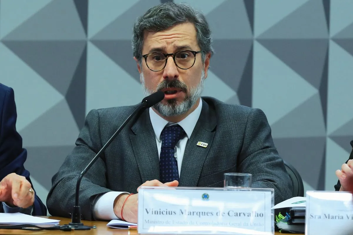 Representante do governo federal discursa ao microfone durante reunião institucional em ambiente oficial