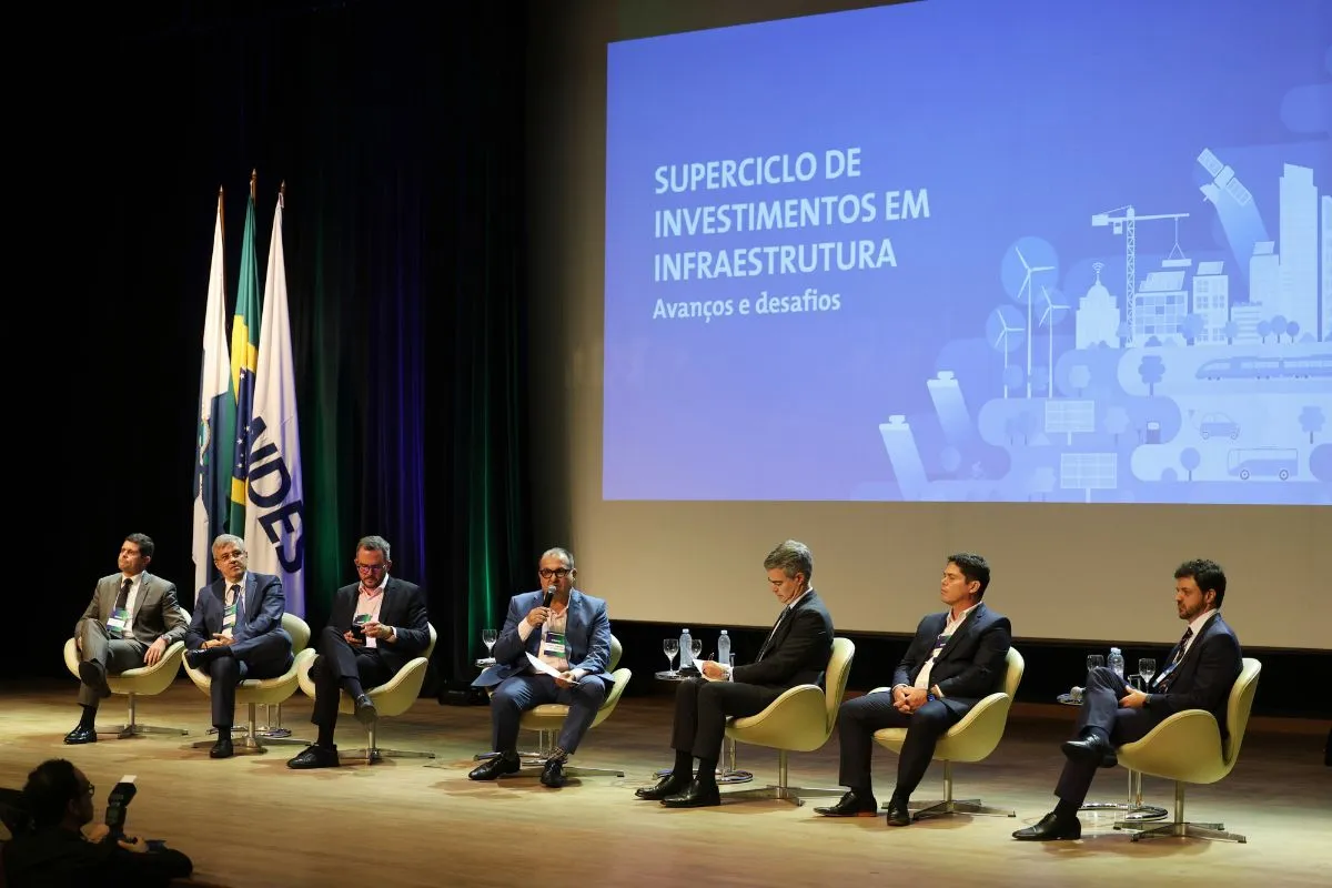Painel de especialistas debatendo superciclo de investimentos em infraestrutura no Brasil durante evento institucional