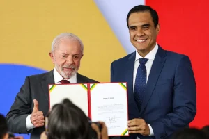 Autoridades federais participam de cerimônia de posse, exibindo termo assinado durante evento oficial do governo brasileiro.