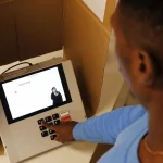 Homem digita número na urna eletrônica durante votação para governador nas eleições brasileiras.