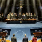 Sessão plenária no Senado Federal com parlamentares em pé durante cerimônia oficial em Brasília