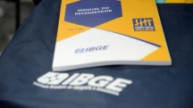 Manual do Recenseador do IBGE sobre colete oficial durante preparação para o Censo Demográfico.