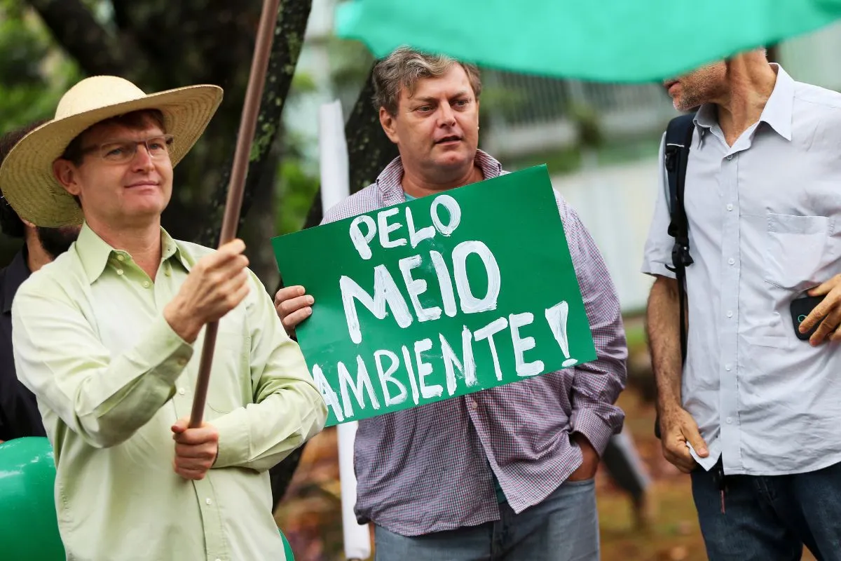Manifestantes seguram cartaz com a frase Pelo Meio Ambiente durante ato público no Brasil.