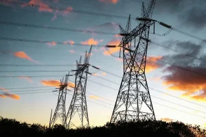 Torres de transmissão de energia elétrica ao entardecer representando infraestrutura do sistema elétrico brasileiro.