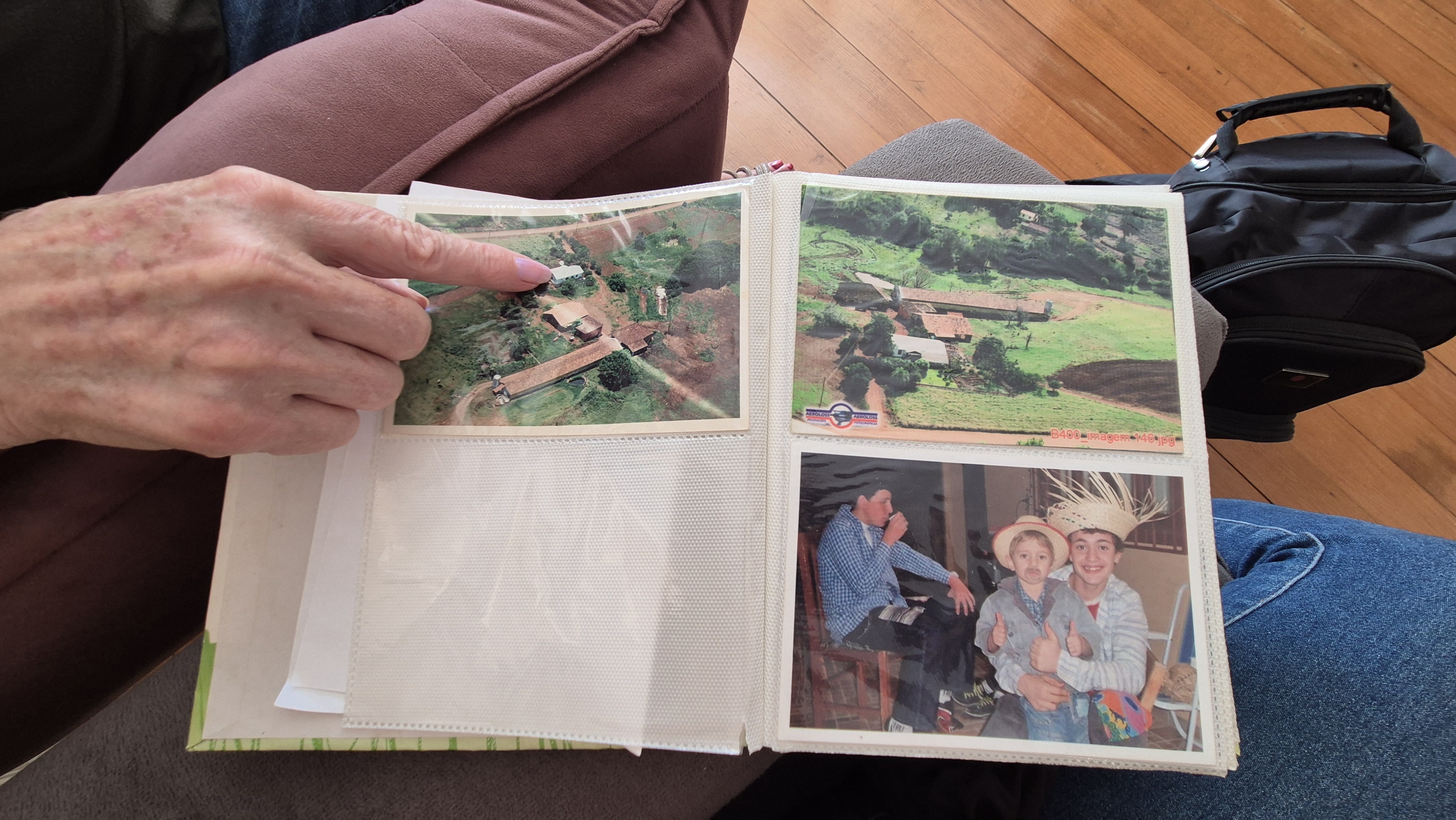 Marlise, mãe de Fernando, aponta para a foto da fazenda da família, vista de cima | Foto: Tauany Cattan/Revista Oeste