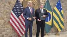 Foto do governador de Goiás, Ronaldo Caiado, e o Encarregado de Negócios na Embaixada dos Estados Unidos em Brasília, Gabriel Escobar. Ambos seguram na mão o memorando assinado por Caiado e Escobar, sobre a cooperação de minerais críticos (terras raras), no consulado dos EUA em São Paulo.