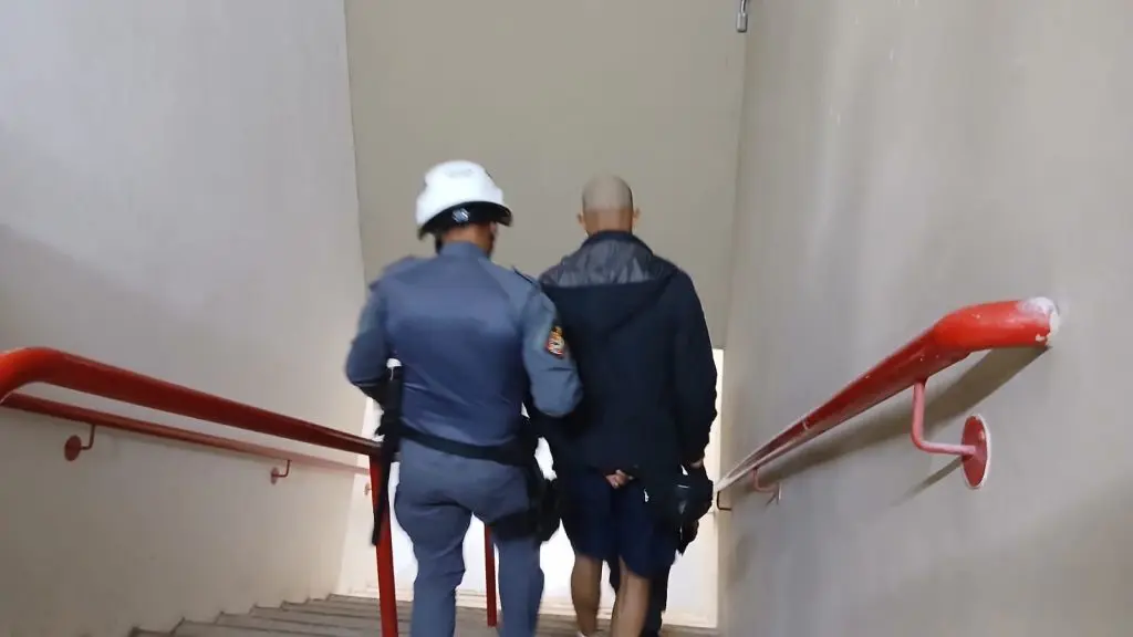 policial militar prendendo homem identificado pelas câmeras de reconhecimento facial do programa Muralha Paulista, em estádio Arena Morumbi, durante o jogo de futebol