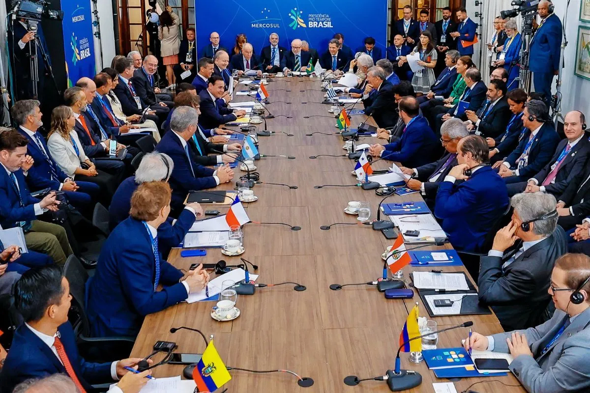 Chefes de Estado e autoridades reunidos em mesa do Mercosul com bandeiras dos países membros