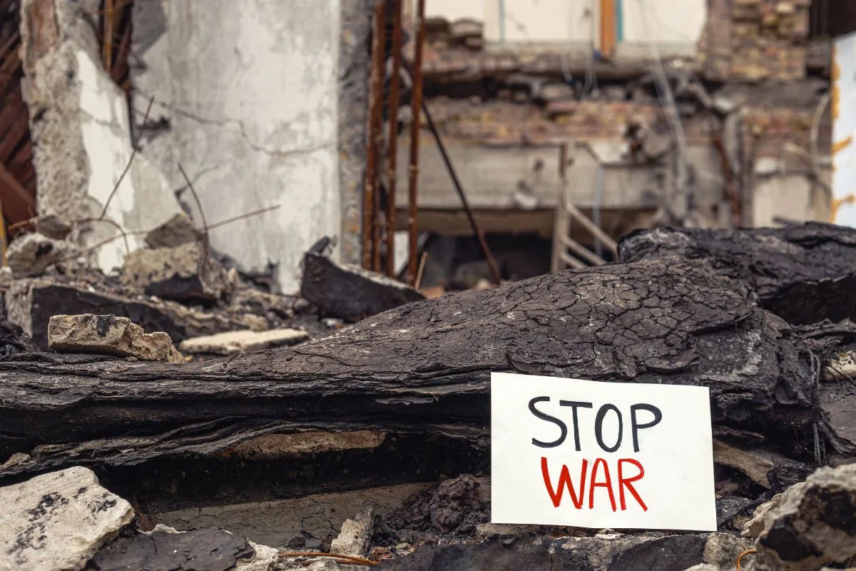 Placa com mensagem Stop War em meio a escombros e ruínas após conflito armado