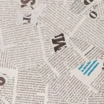 Recortes de jornais com a expressão fake news em destaque representando desinformação na mídia.