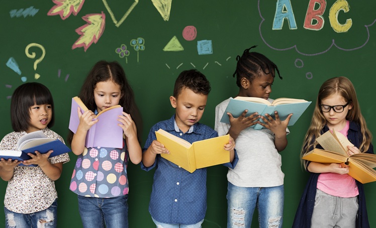 Crianças leem livros, em alusão à matéria sobre SP atingir meta de alfabetização na idade certa com 360 mil alunos