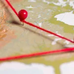 Mapa com alfinetes vermelhos conectados por linha indicando rotas ou escalada de conflito geopolítico