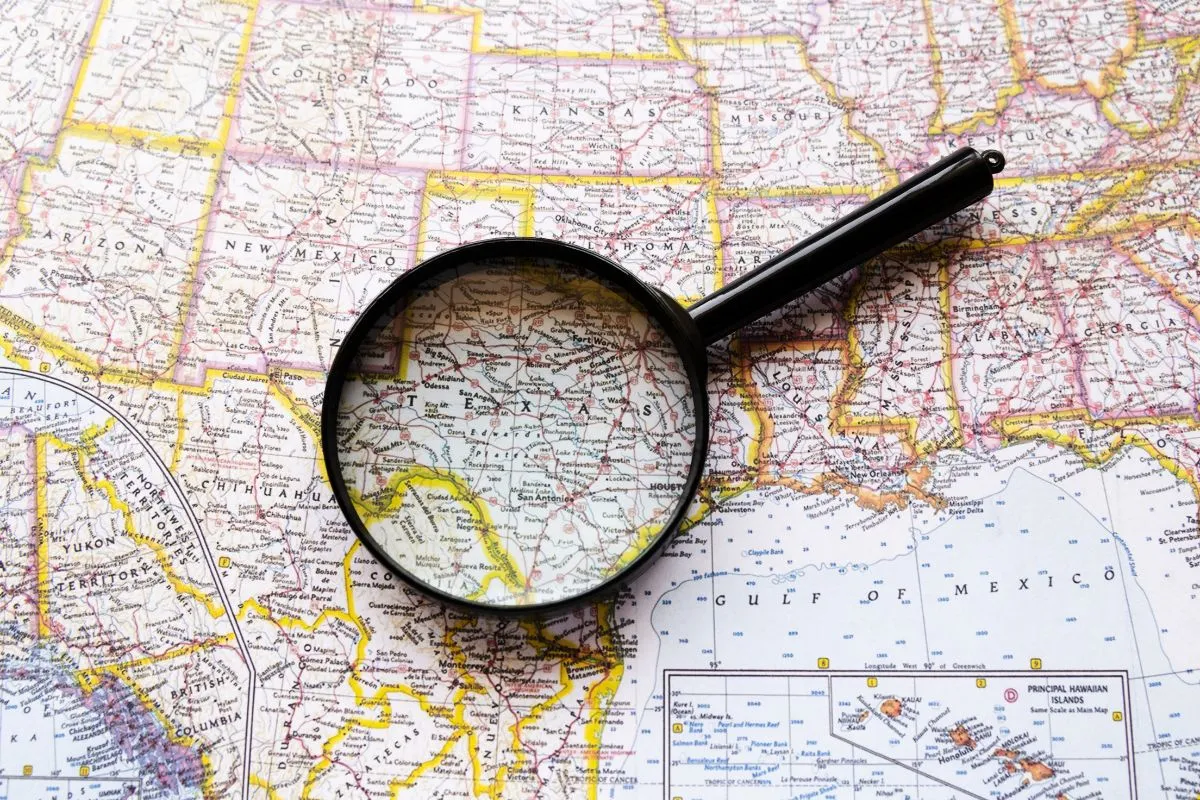 Lupa sobre mapa dos Estados Unidos focando na região do Texas e estados vizinhos