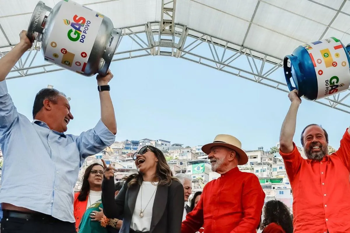 Autoridades levantando botijões do programa Gás do Povo durante evento de política social