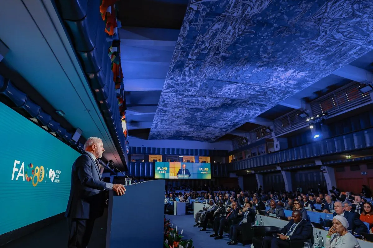 Autoridade discursando em evento da FAO com plateia internacional e painel ao fundo