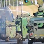 Veículos militares do Exército Brasileiro em comboio com blindados e caminhões em estrada urbana
