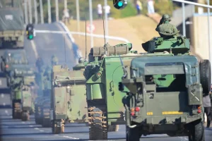 Veículos militares do Exército Brasileiro em comboio com blindados e caminhões em estrada urbana