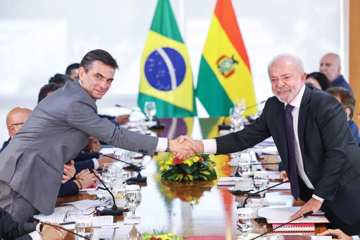 Representantes do Brasil e da Bolívia apertam as mãos durante reunião diplomática oficial