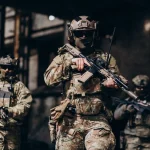 Soldados equipados com uniformes táticos e armas em missão de segurança em ambiente urbano