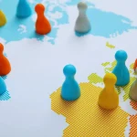 Peças coloridas sobre mapa mundial simbolizando países e conexões geopolíticas globais