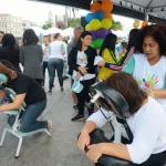 Profissionais realizando massagem em participantes durante ação social de saúde e bem-estar em evento público