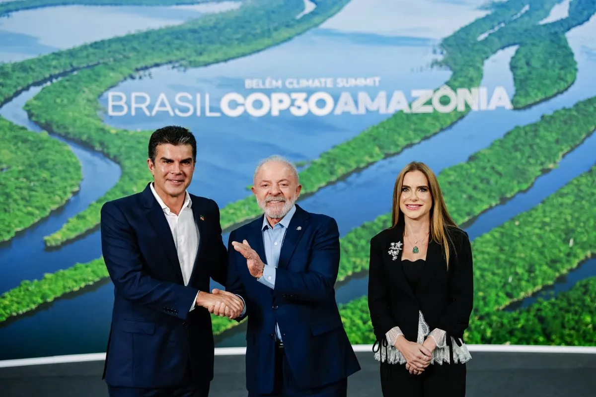 Autoridades políticas posam durante evento COP30 Amazônia com cenário de rios e floresta