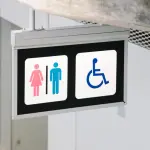 Placa mostra opções de banheiros masculino, feminino e para pessoas com deficiência, em alusão à nota sobre proibição de uso de banheiro feminino por trans em Campo Grande