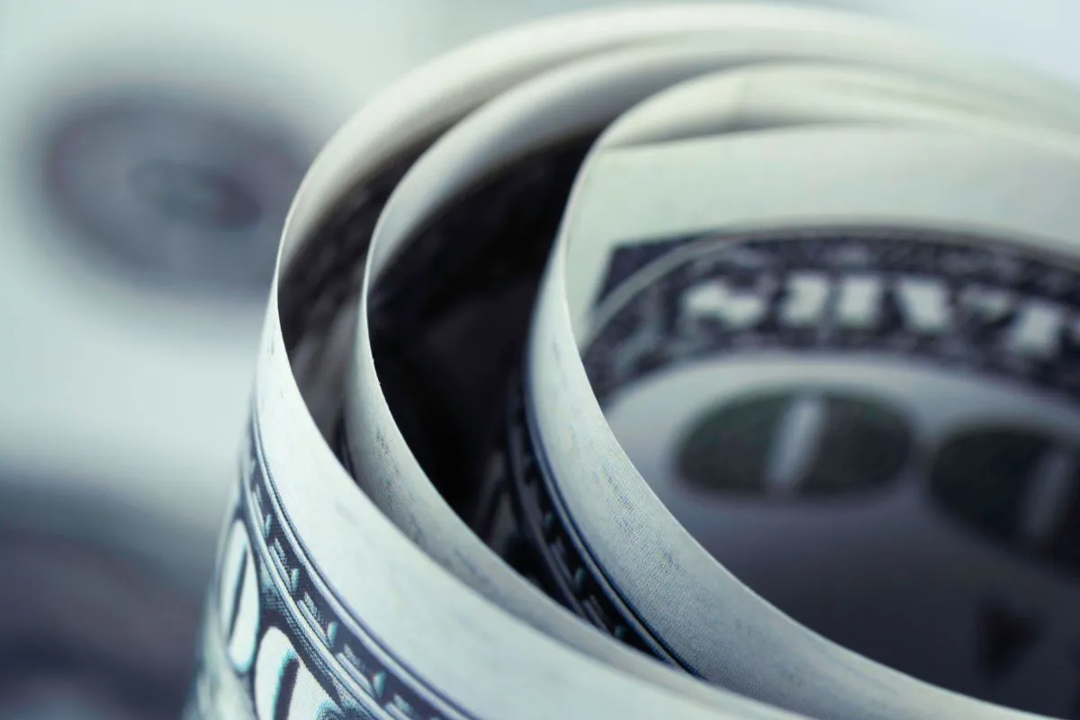 Notas de dólar enroladas em close simbolizando câmbio e economia global