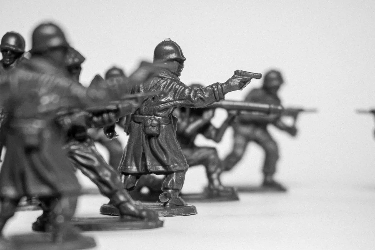 Miniaturas de soldados armados em posição de combate, representando guerra e estratégia militar