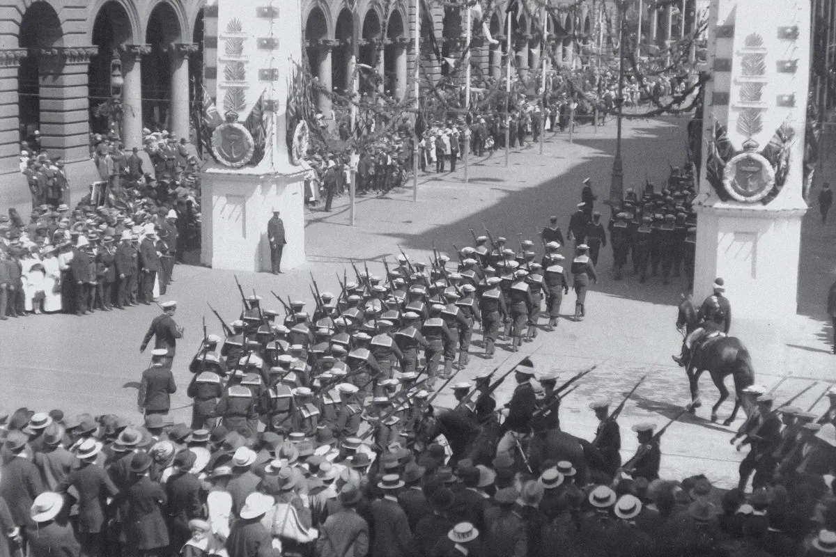 Tropas militares antigas marchando em desfile histórico com soldados uniformizados e público ao redor