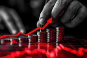 Pilhas de moedas com seta vermelha ascendente representando inflação e aumento de preços