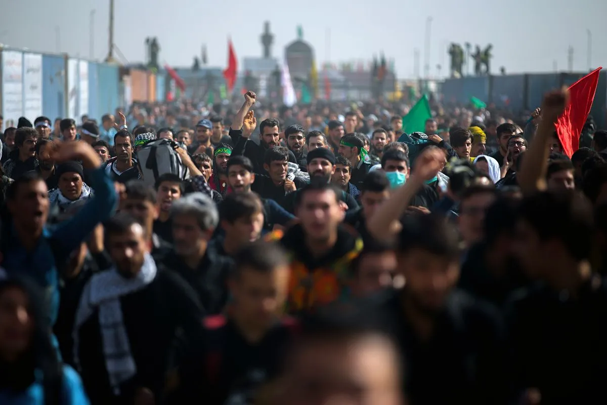 Multidão em protesto com pessoas marchando e levantando punhos em manifestação política
