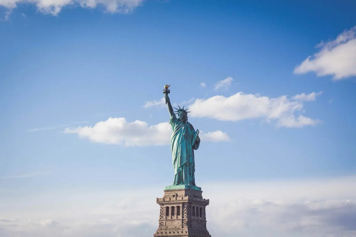 Estátua da Liberdade em Nova York sob céu azul representando liberdade e democracia