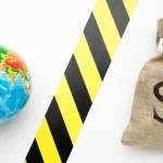 Globo terrestre e saco de dinheiro com símbolo de dólar separados por faixa de bloqueio, representando protecionismo econômico