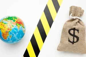 Globo terrestre e saco de dinheiro com símbolo de dólar separados por faixa de bloqueio, representando protecionismo econômico