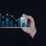 Mão desenhando gráfico de barras para comparar dados econômicos históricos e tendências de mercado.