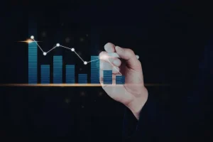 Mão desenhando gráfico de barras para comparar dados econômicos históricos e tendências de mercado.
