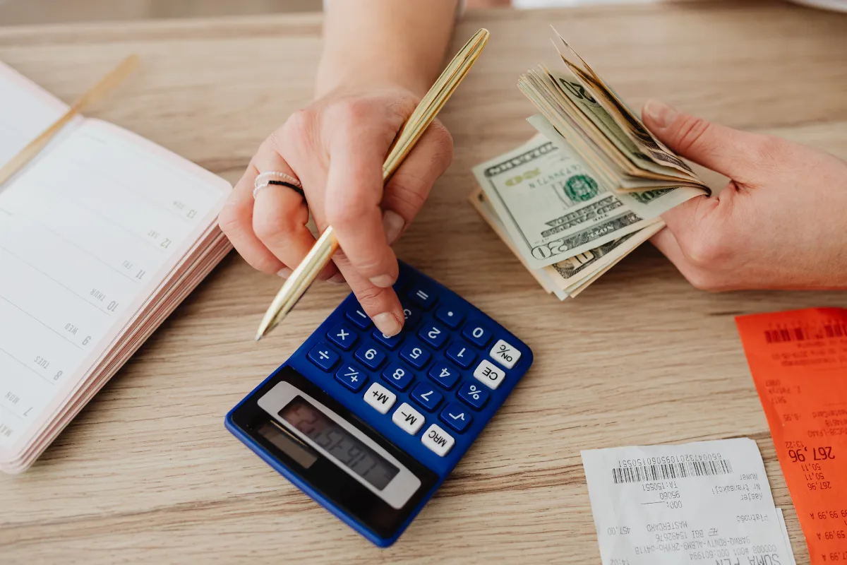 Calculadora azul, recibos e notas de dólar durante análise fiscal de subsídios e despesas governamentais