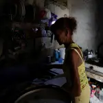 Ana Maria Vazquez prepara café em sua casa, enquanto a rede elétrica de Cuba sofreu um colapso parcial na madrugada de 14 de maio deste ano | Foto: Norlys Perez/Reuters
