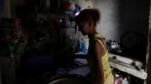 Ana Maria Vazquez prepara café em sua casa, enquanto a rede elétrica de Cuba sofreu um colapso parcial na madrugada de 14 de maio deste ano | Foto: Norlys Perez/Reuters