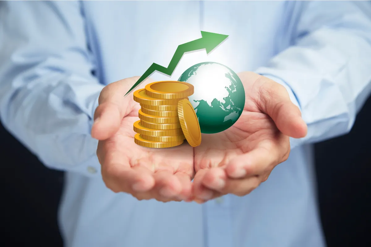 Mãos segurando moedas e globo com seta de crescimento, simbolizando investimentos e desenvolvimento econômico global