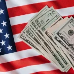 Notas de dólar sobre bandeira dos Estados Unidos representando economia americana