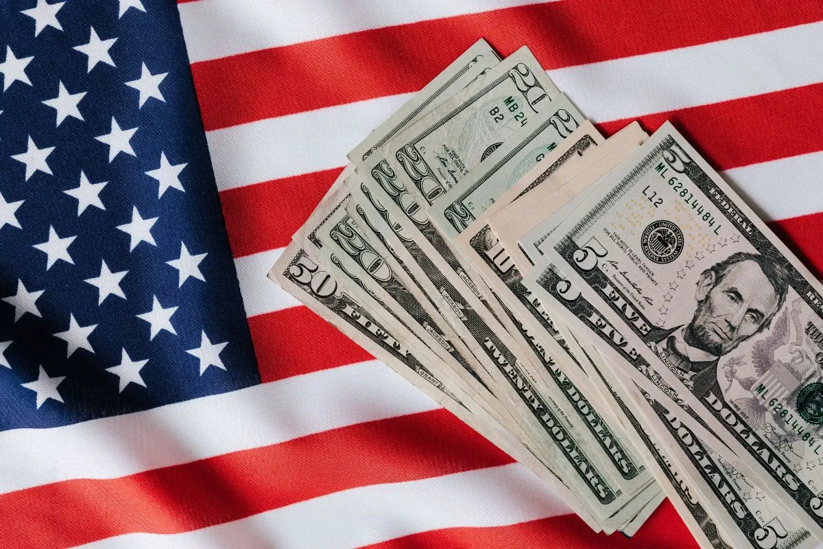 Notas de dólar sobre bandeira dos Estados Unidos representando economia americana