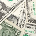 Cédulas de dólar americano sobrepostas mostrando detalhes da moeda dos EUA