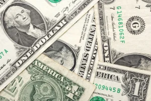 Cédulas de dólar americano sobrepostas mostrando detalhes da moeda dos EUA
