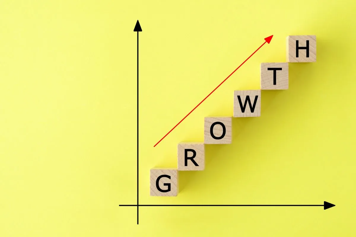 Blocos formando a palavra growth com seta de alta representando indicadores de crescimento econômico e mercado