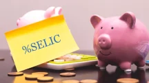 Cofrinho com moedas e papel escrito Selic representando taxa de juros e investimentos